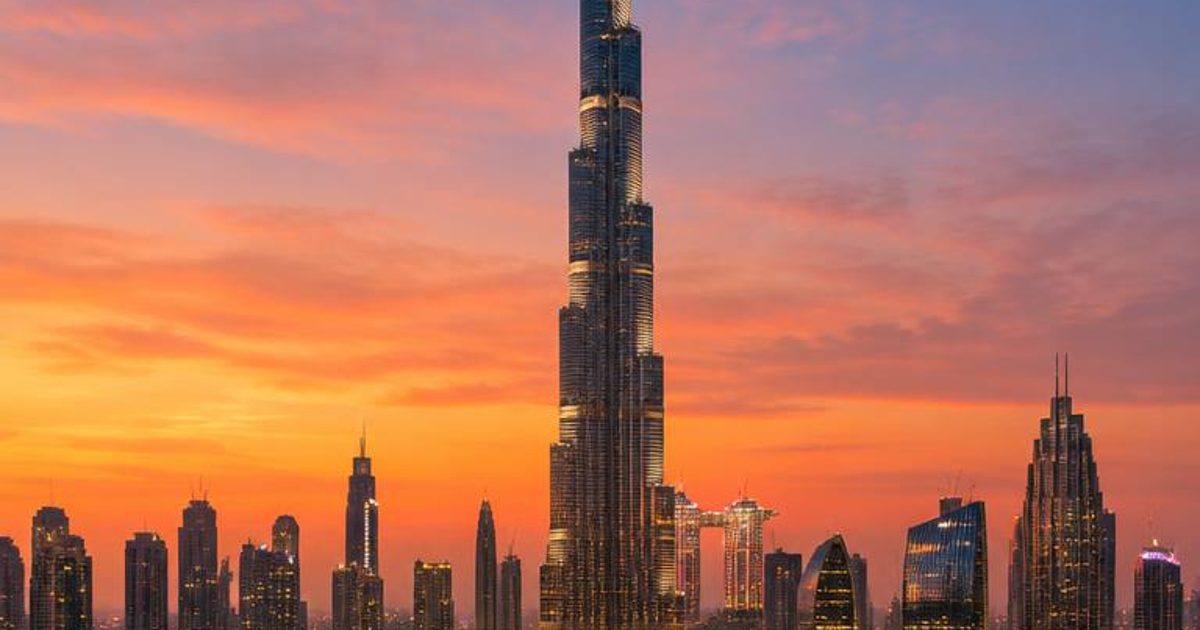 Burj Khalifa and the Downtown skyline beside water at sunset